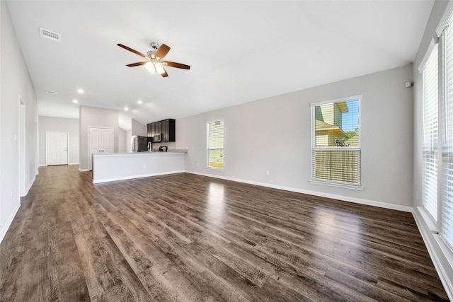 unfurnished living room featuring a healthy amount of sunlight, dark hardwood / wood-style flooring, and lofted ceiling