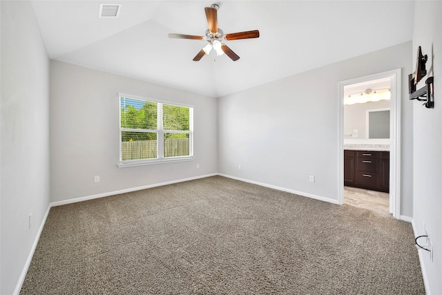 unfurnished bedroom featuring ensuite bathroom, ceiling fan, light carpet, and vaulted ceiling