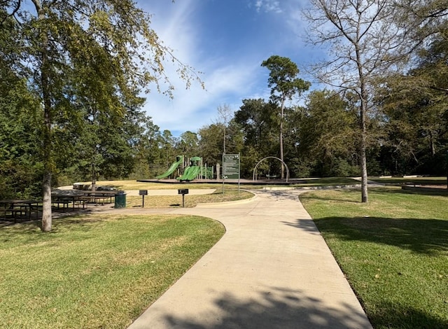 view of home's community with a lawn and a playground