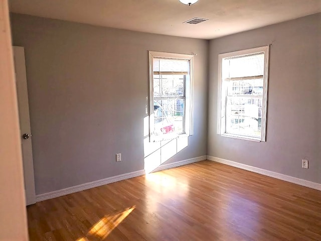 unfurnished room with plenty of natural light and hardwood / wood-style floors