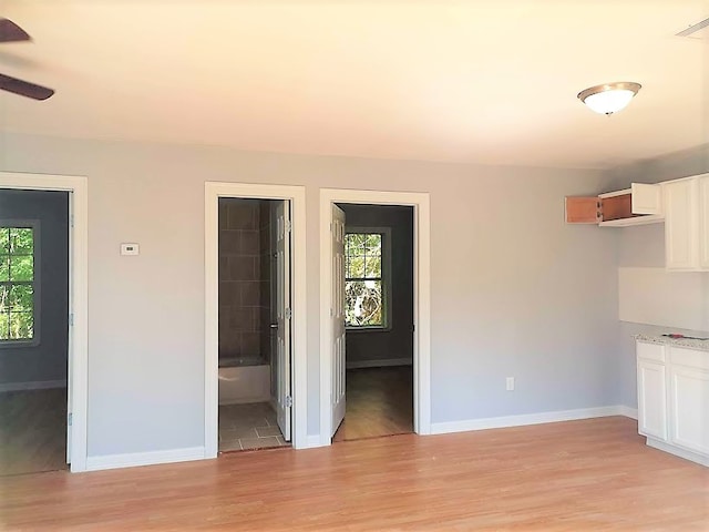 interior space with ceiling fan, light wood-type flooring, and a healthy amount of sunlight