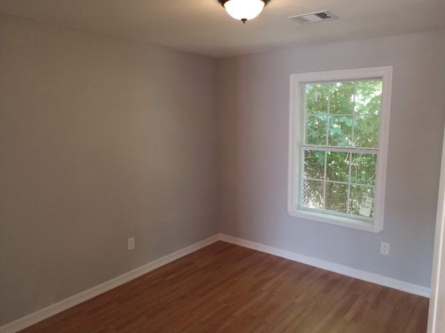 empty room featuring wood-type flooring and a healthy amount of sunlight