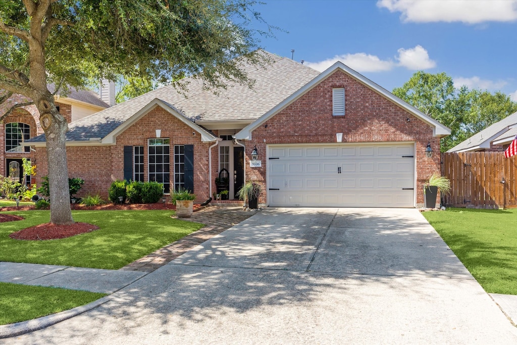 view of front of home with a front yard and a garage