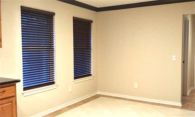 tiled empty room featuring ornamental molding