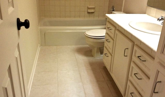 bathroom with a tub, vanity, tile patterned flooring, and toilet