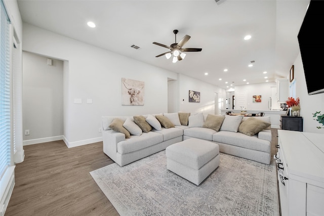 living room featuring ceiling fan and light hardwood / wood-style floors