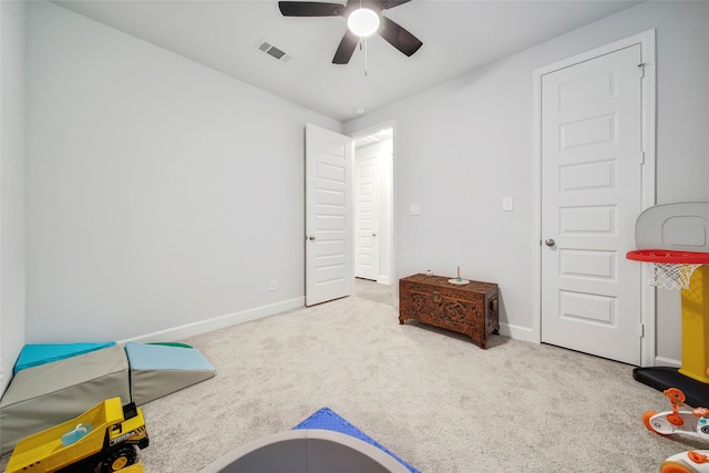 playroom featuring light carpet and ceiling fan