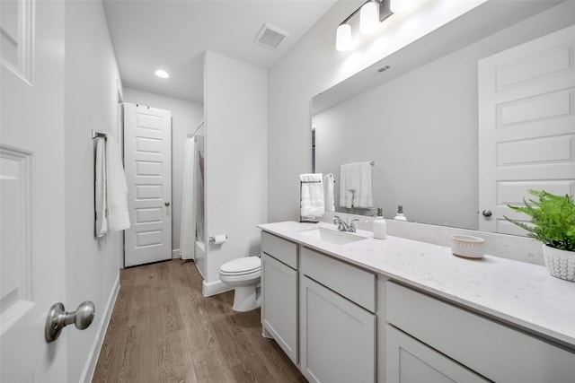 bathroom featuring hardwood / wood-style flooring, vanity, toilet, and a shower with shower curtain