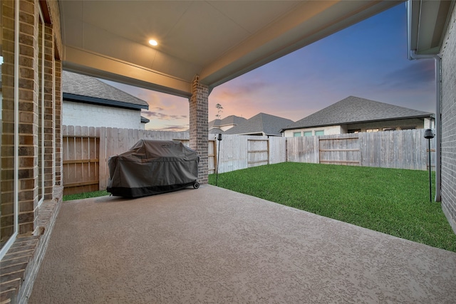 patio terrace at dusk with a yard and a grill