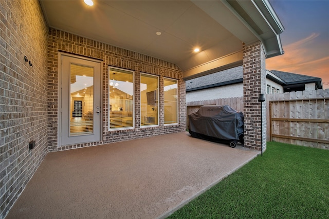 patio terrace at dusk with a yard and a grill