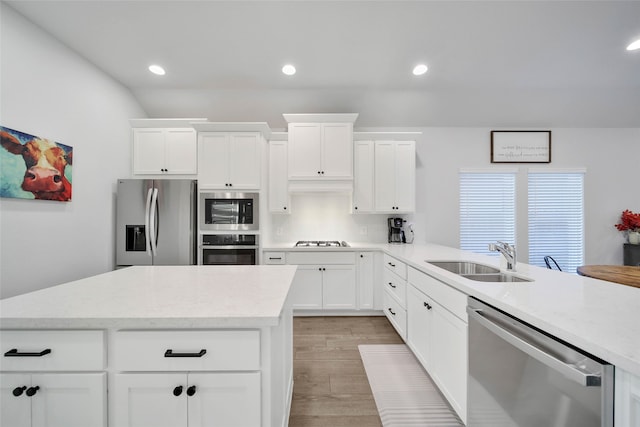 kitchen with light wood-type flooring, white cabinetry, sink, and stainless steel appliances