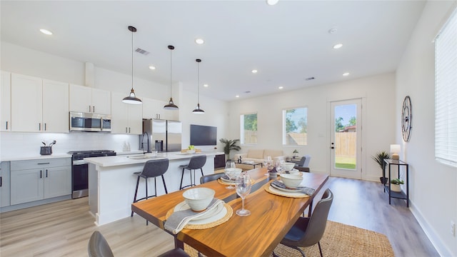 dining space with sink and light hardwood / wood-style floors