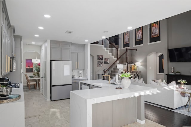 kitchen with sink, gray cabinets, a spacious island, and appliances with stainless steel finishes