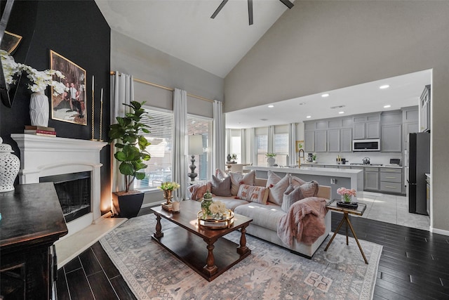 living room featuring ceiling fan and high vaulted ceiling