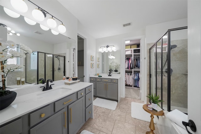 bathroom featuring vanity, a shower with shower door, and tile patterned floors