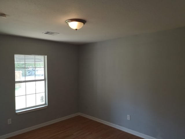 spare room featuring hardwood / wood-style floors and a textured ceiling