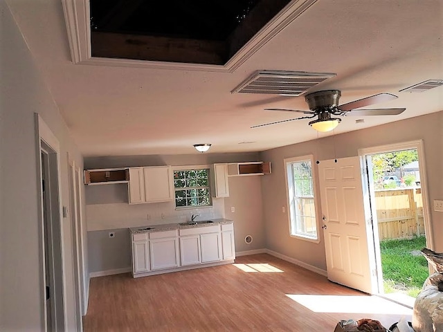 kitchen featuring light hardwood / wood-style flooring, white cabinetry, sink, and ceiling fan