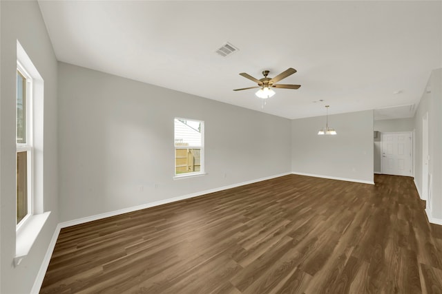 unfurnished room featuring ceiling fan with notable chandelier and dark hardwood / wood-style flooring