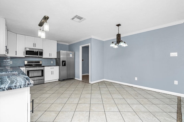 kitchen with a chandelier, tasteful backsplash, decorative light fixtures, white cabinets, and appliances with stainless steel finishes