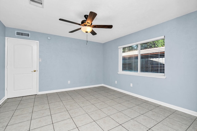 tiled spare room featuring ceiling fan