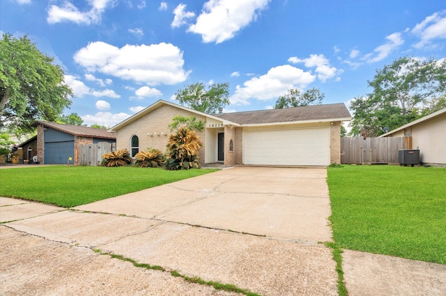 view of front of property featuring a front yard, cooling unit, and a garage