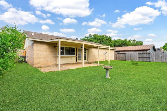 back of house with a yard and a patio