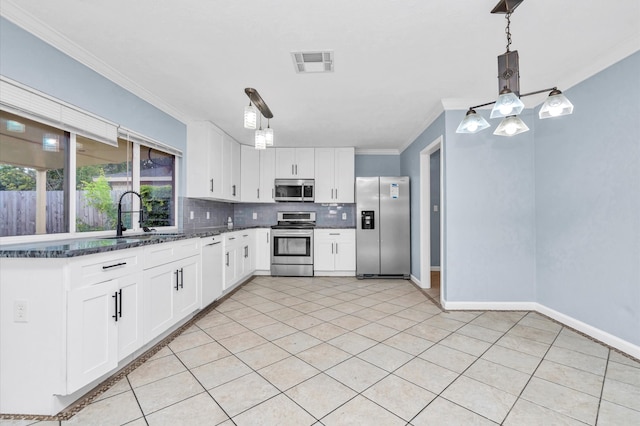 kitchen with decorative light fixtures, appliances with stainless steel finishes, sink, and white cabinetry