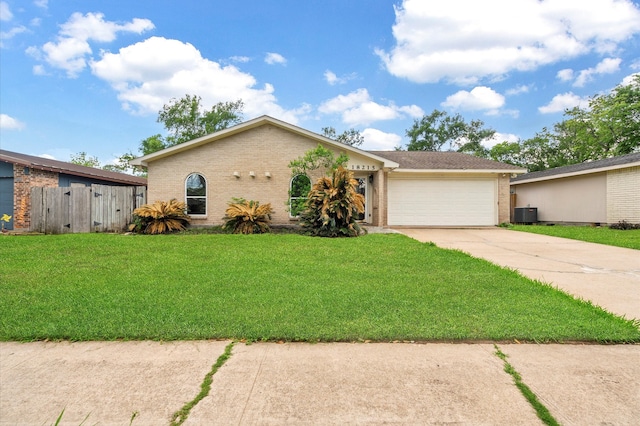 ranch-style house featuring a garage, a front lawn, and central AC unit