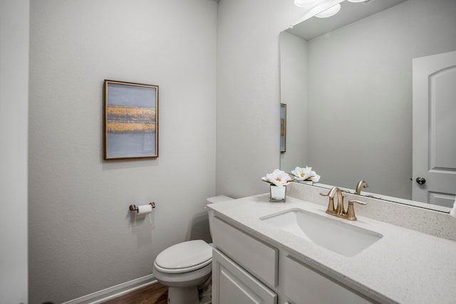 bathroom with hardwood / wood-style flooring, vanity, and toilet