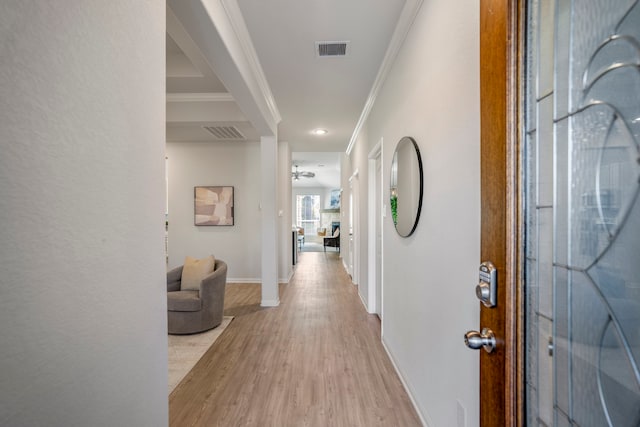 corridor featuring ornamental molding and light hardwood / wood-style flooring