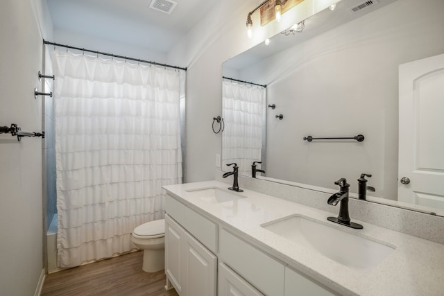 full bathroom with vanity, hardwood / wood-style floors, toilet, and shower / bath combo