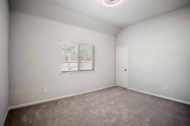 empty room with vaulted ceiling and carpet