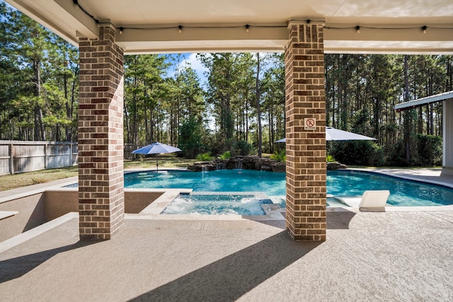 view of pool with a patio, an in ground hot tub, and pool water feature