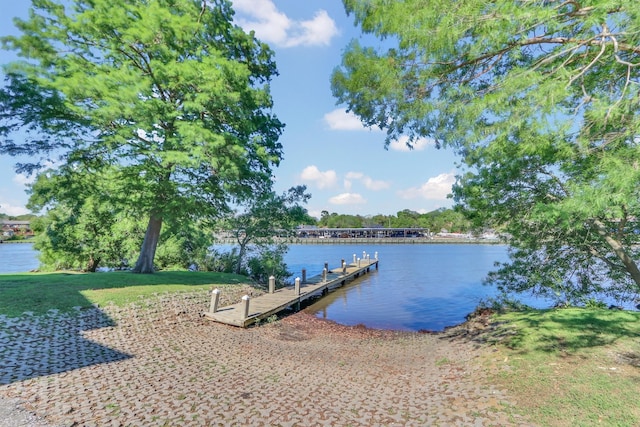 dock area with a water view and a lawn