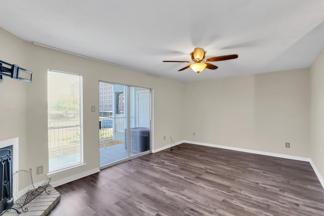 unfurnished living room featuring dark wood-type flooring and ceiling fan