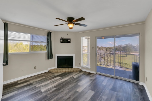 unfurnished living room featuring a healthy amount of sunlight, ceiling fan, and dark hardwood / wood-style flooring