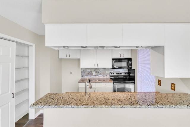 kitchen featuring stainless steel electric stove, white cabinets, kitchen peninsula, light stone countertops, and dark hardwood / wood-style floors