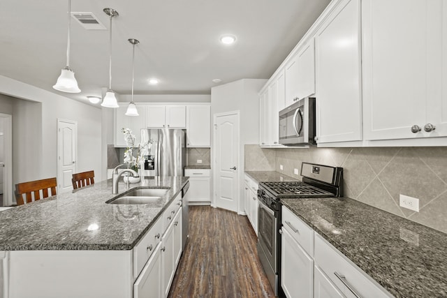 kitchen with white cabinets, sink, a center island with sink, dark wood-type flooring, and appliances with stainless steel finishes