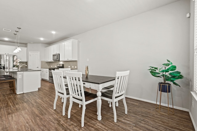 dining room featuring dark wood-type flooring and sink