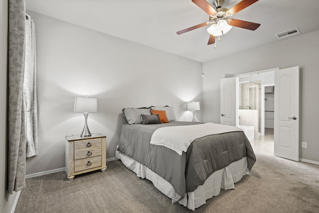 bedroom featuring ensuite bathroom, ceiling fan, and dark carpet