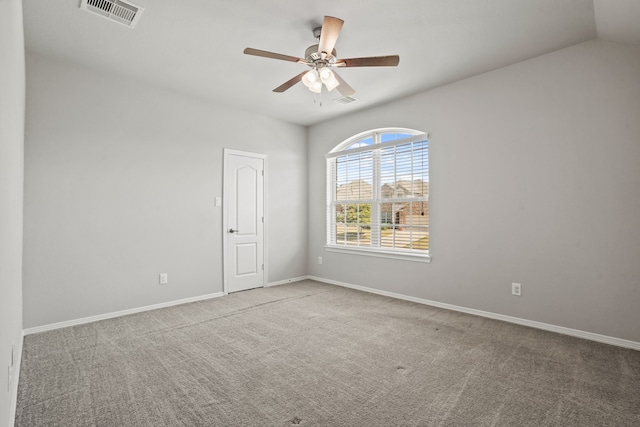 empty room featuring ceiling fan, vaulted ceiling, and light colored carpet