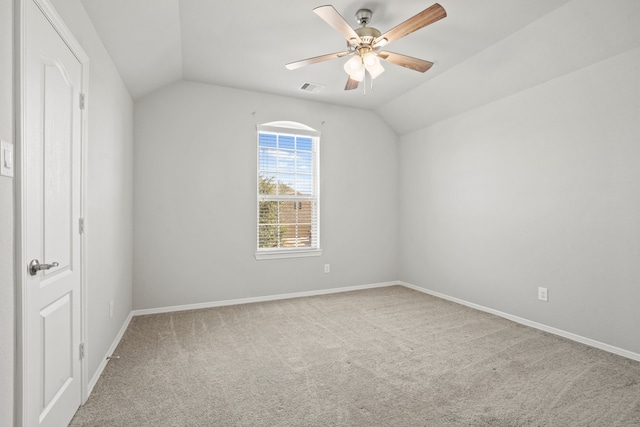 carpeted spare room with ceiling fan and vaulted ceiling