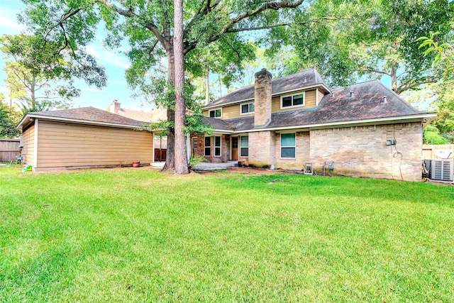 back of property with central air condition unit and a lawn