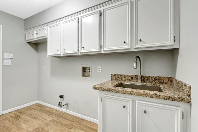 laundry area with hookup for a gas dryer, sink, light hardwood / wood-style flooring, washer hookup, and cabinets