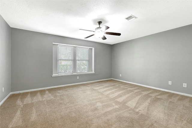 carpeted empty room featuring a textured ceiling and ceiling fan