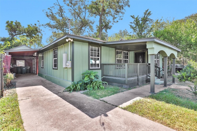 view of front of home with driveway, a porch, and an attached carport