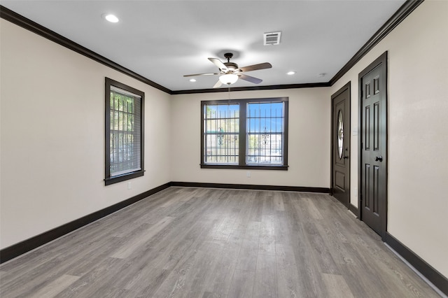 empty room with crown molding, light wood-type flooring, a wealth of natural light, and ceiling fan