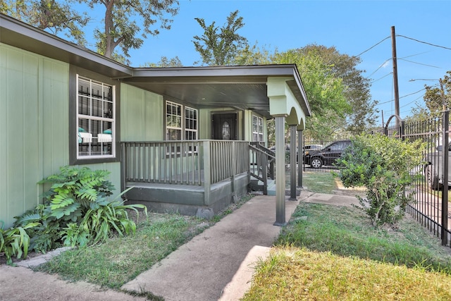 property entrance with fence and a porch