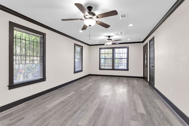 empty room with ornamental molding, light wood-type flooring, and a healthy amount of sunlight