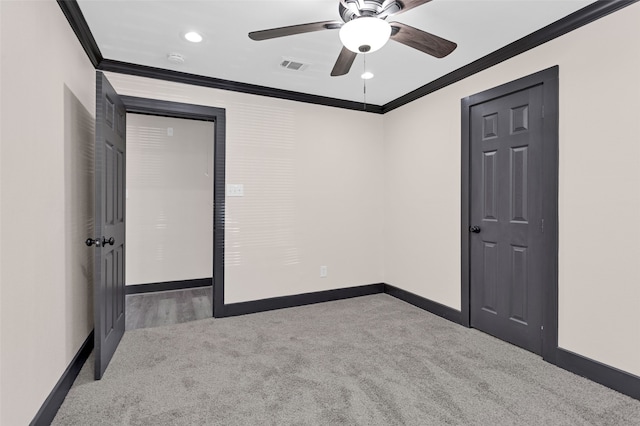 spare room featuring crown molding, carpet, and ceiling fan